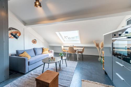 un salon avec un canapé bleu et une table dans l'établissement The White Duplex, à Annecy