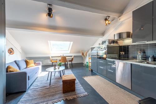 une cuisine et un salon avec un canapé et une table dans l'établissement The White Duplex, à Annecy