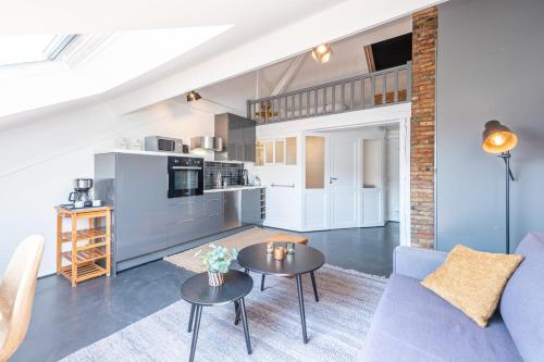 un salon avec un canapé bleu et une table dans l'établissement The White Duplex, à Annecy