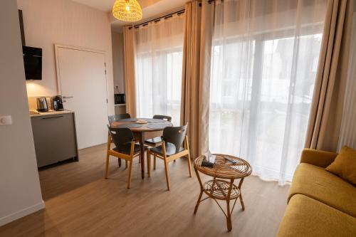 a living room with a table and chairs and a couch at The Originals City, Ara Hôtel, Landerneau in Landerneau