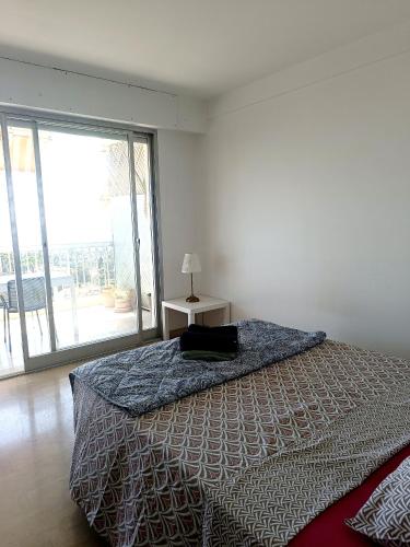 une chambre avec un lit et une lampe sur une table dans l'établissement Vue imprenable cannes, à Cannes