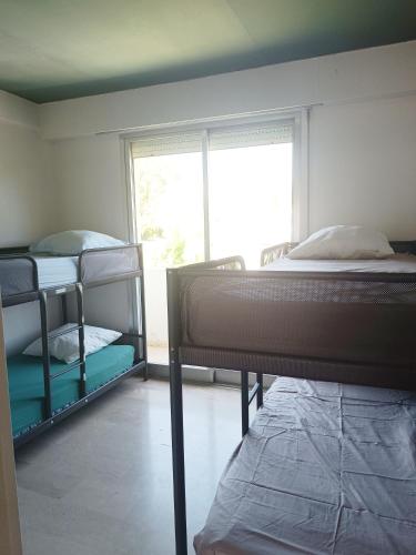 une chambre avec deux lits superposés et une fenêtre dans l'établissement Vue imprenable cannes, à Cannes