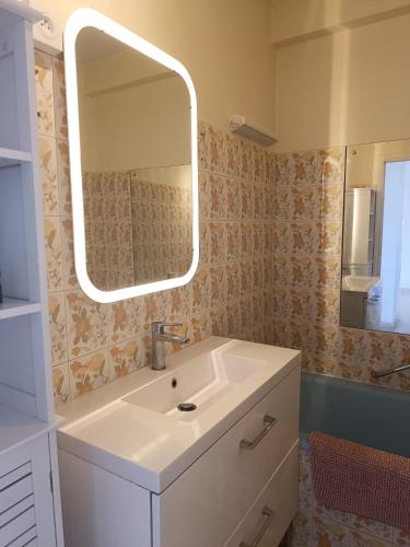 une salle de bain avec un lavabo et un miroir dans l'établissement Vue imprenable cannes, à Cannes