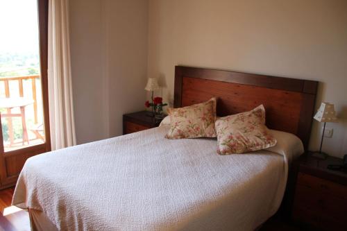 a bedroom with a bed with two pillows on it at Villa Mencia in Corullón