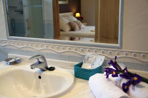 un bancone del bagno con lavandino e specchio di Villa Mencia a Corullón