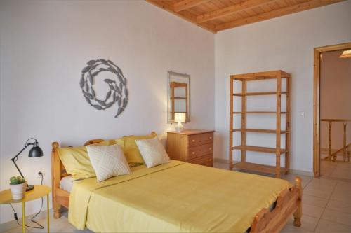 1 dormitorio con cama grande y escalera de madera en The house with the arches, en Sfakerá