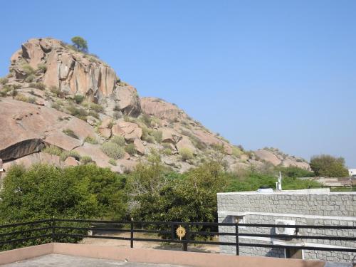 a rocky hill with a building and a mountain at JAWAI WILD LODGE in Bijāpur