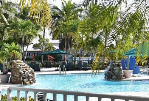 a swimming pool with palm trees in a resort at 7940 # 626, Naples, FL in Naples