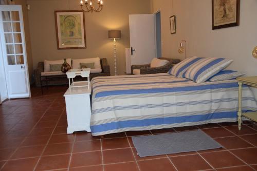 a bedroom with a bed with a blue and white striped blanket at Moulin des Gypses Gîte Les Pierres Blanches, Ventoux in Mormoiron