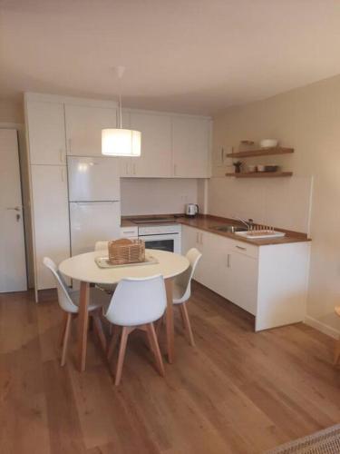 a kitchen with a table and chairs and a kitchen with a sink at Apartamento Dana próximo a la playa - Costa da Morte in Zas