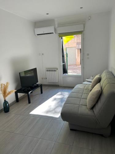 un salon avec un canapé et une télévision dans l'établissement Studio Riviera proche de Cannes, au Cannet