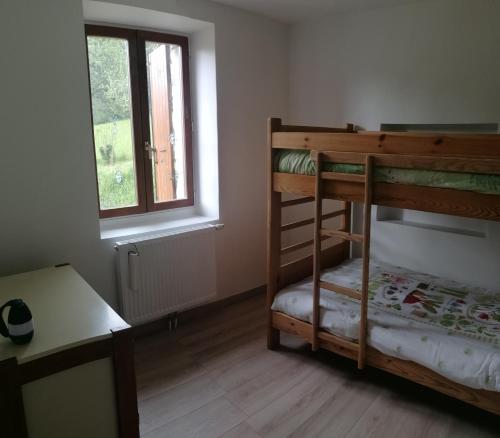 une chambre avec deux lits superposés et une fenêtre dans l'établissement Gîtes Belle Échappée - Serre Plumé, à La Chapelle-en-Vercors