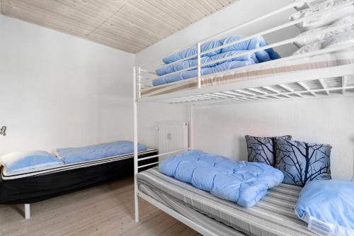 a bedroom with two bunk beds and blue pillows at Lovely Holiday Apartment Centrally Located In Løkken in Løkken