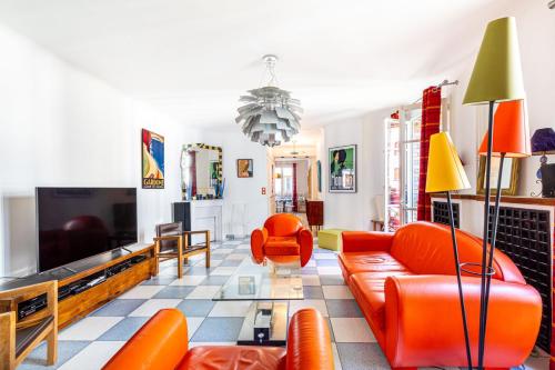 Il comprend un salon doté d'un mobilier orange et d'une télévision. dans l'établissement GuestReady -Logement accueillant proche Montmartre, à Paris