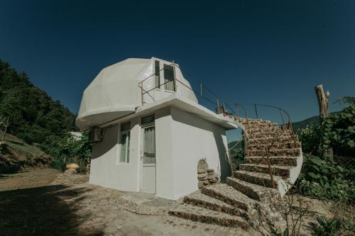a white building with stairs leading up to it at Amaghlebakari in Batumi