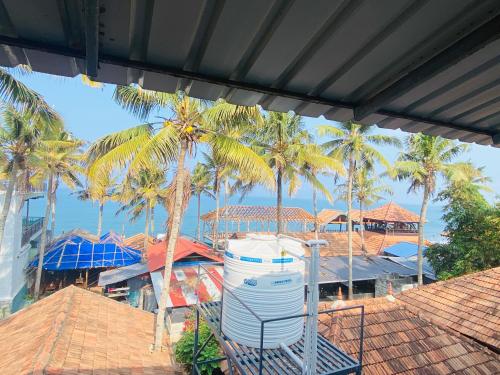 a view of palm trees and a building with a water tank at Paradise Inn Beach Resort in Varkala