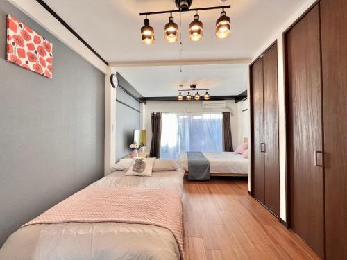 a bedroom with two beds and a window at KKHouse in Tokyo