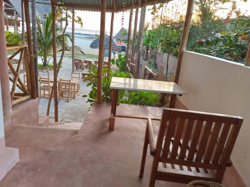 a table and chairs in a room with a view of the beach at Ndiro Beach House Kendwa in Kendwa