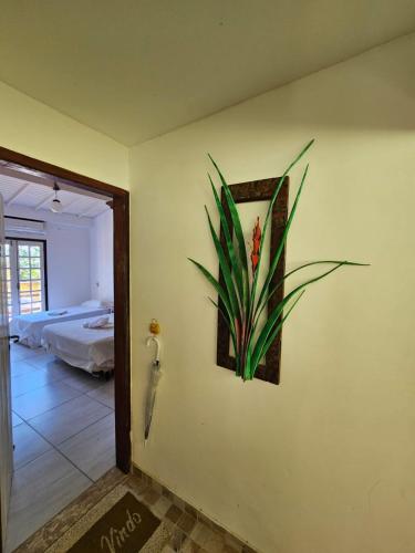 a painting of a flower on a wall in a room at Pousada Éden in Angra dos Reis