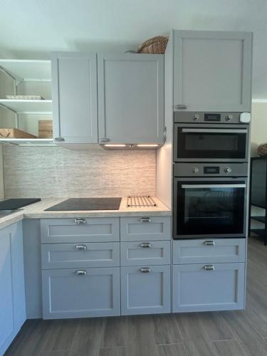 a kitchen with white cabinets and a stove top oven at Dimora Manganedda in Arzachena
