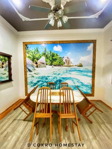 a dining room with a painting of the ocean at Dchokro Homestay Parit Raja UTHM in Parit Raja