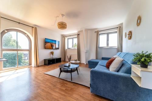 a living room with a blue couch and a table at Le Saint-Jean - Hypercentre - Parking privé - 1 à 6 personnes - Wifi in Roubaix