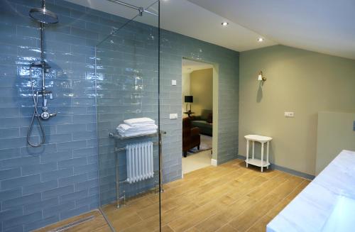 a bathroom with a shower with blue tiles at Het Ros van Twente in De Lutte
