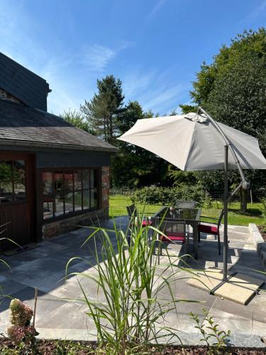 a patio with a table and an umbrella at Little Roua Ardenne Cottage 4 pers in Stoumont
