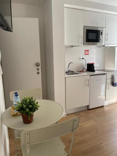 a small white kitchen with a table and chairs at Casa do Museu in Coimbra