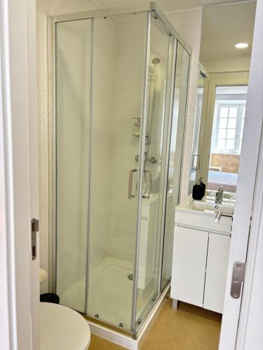 a glass shower in a bathroom with a sink at Casa do Museu in Coimbra