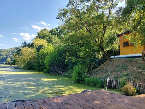 a house on the side of a river with trees at "Kod dva kestena"Warm and cozy house with lake view sauna in Međuvršje