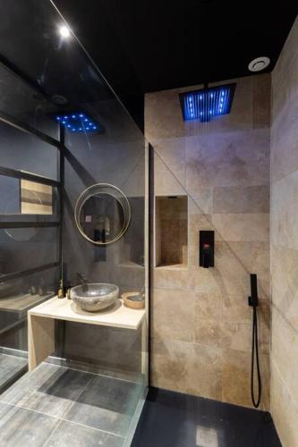 une salle de bain avec un lavabo et un miroir dans l'établissement Le Pont des Amoureux Jacuzzi Wifi, à Cournon-dʼAuvergne