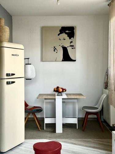 a kitchen with a table and a refrigerator at Terrasse de Paris in Poissy