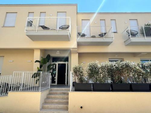 un edificio con scale e piante sui balconi di Hotel Perla a Castiglione della Pescaia