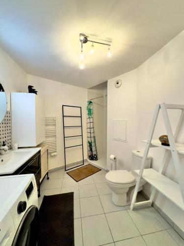 une salle de bain blanche avec des toilettes et un lavabo dans l'établissement Terrasse de Paris, à Poissy