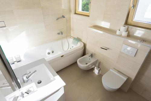 a bathroom with a sink and a toilet and a bath tub at Vertmont Villa in Sveti Stefan