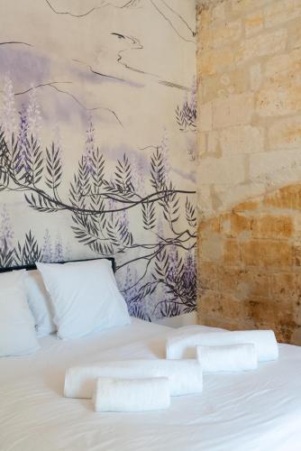 une chambre avec un lit avec deux serviettes dessus dans l'établissement L'Heure Bleue, à Villeneuve-lès-Avignon