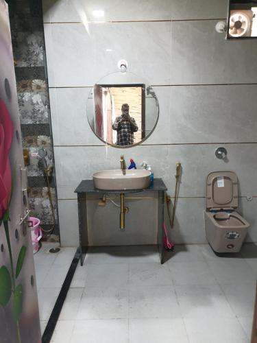 a bathroom with a sink and a mirror and a toilet at RKS INTERNATIONAL HAMPi in Hampi