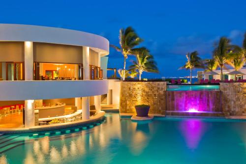 a villa with a swimming pool at night at Altitude at Krystal Grand Cancun - All Inclusive in Cancún