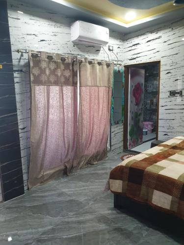 a bedroom with a bed and curtains in a room at RKS INTERNATIONAL HAMPi in Hampi