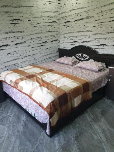 a bed in a room with a brick wall at RKS INTERNATIONAL HAMPi in Hampi