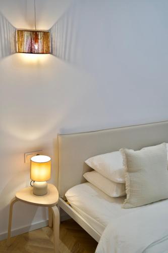 a bed with a lamp on a table next to it at Tzatziki Studios in Kavala