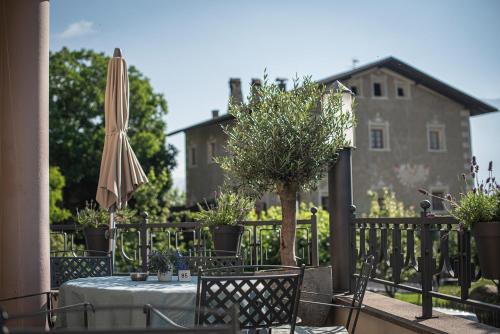 a table with an umbrella and a table and chairs at Taubers Unterwirt Aktiv & Vitalhotel in Feldthurns
