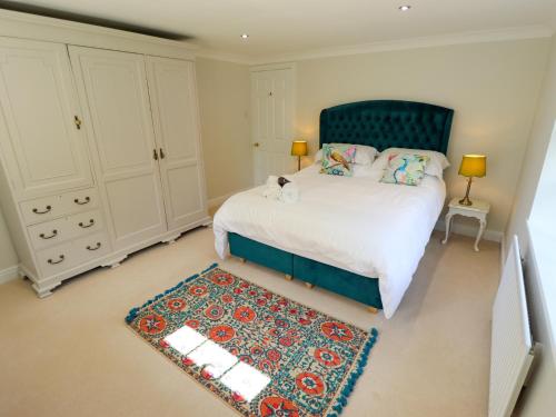 a bedroom with a bed with a blue headboard and a rug at Moon Field Lodge in Scunthorpe