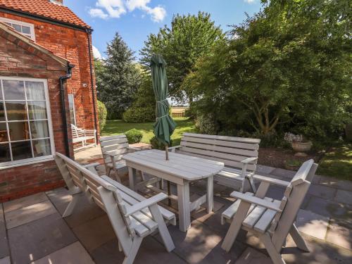 a patio with a table and chairs and an umbrella at Moon Field Lodge in Scunthorpe