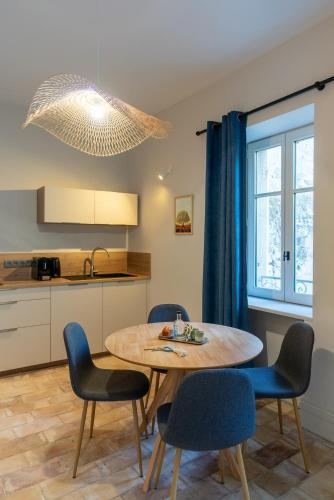 une cuisine et une salle à manger avec une table et des chaises dans l'établissement L'Heure Bleue, à Villeneuve-lès-Avignon
