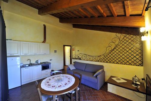 a kitchen and a living room with a couch and a table at Il Podere Del Germano Reale in Coriano