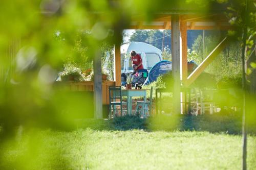 a woman sitting at a table in a gazebo at Camping Baleia in Pui