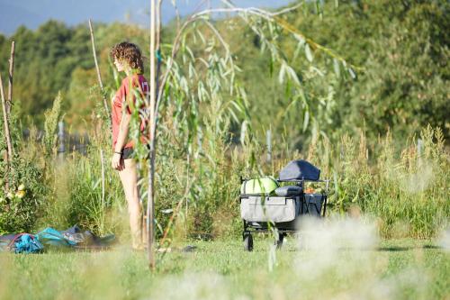 a woman standing in the grass next to a grill at Camping Baleia in Pui