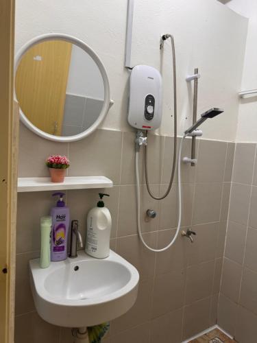 a bathroom with a sink and a shower with a mirror at skyview relax 2BR 1car park arenaspice airport domestic guest only in Bayan Lepas